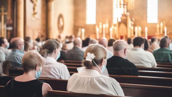 People sitting in pews in a church wearing face masks.